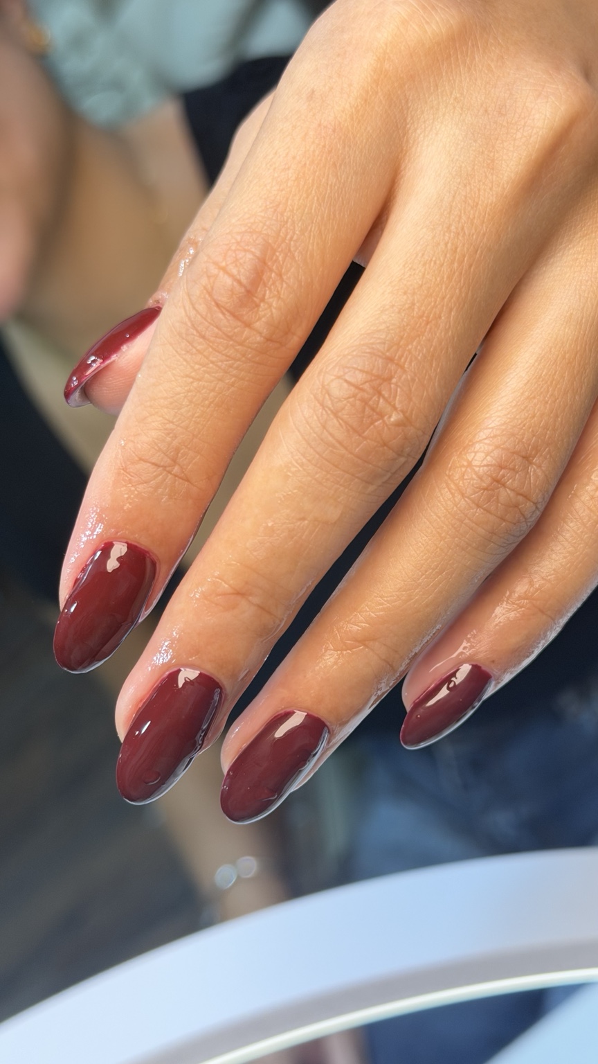 Glossy burgundy almond-shaped manicure